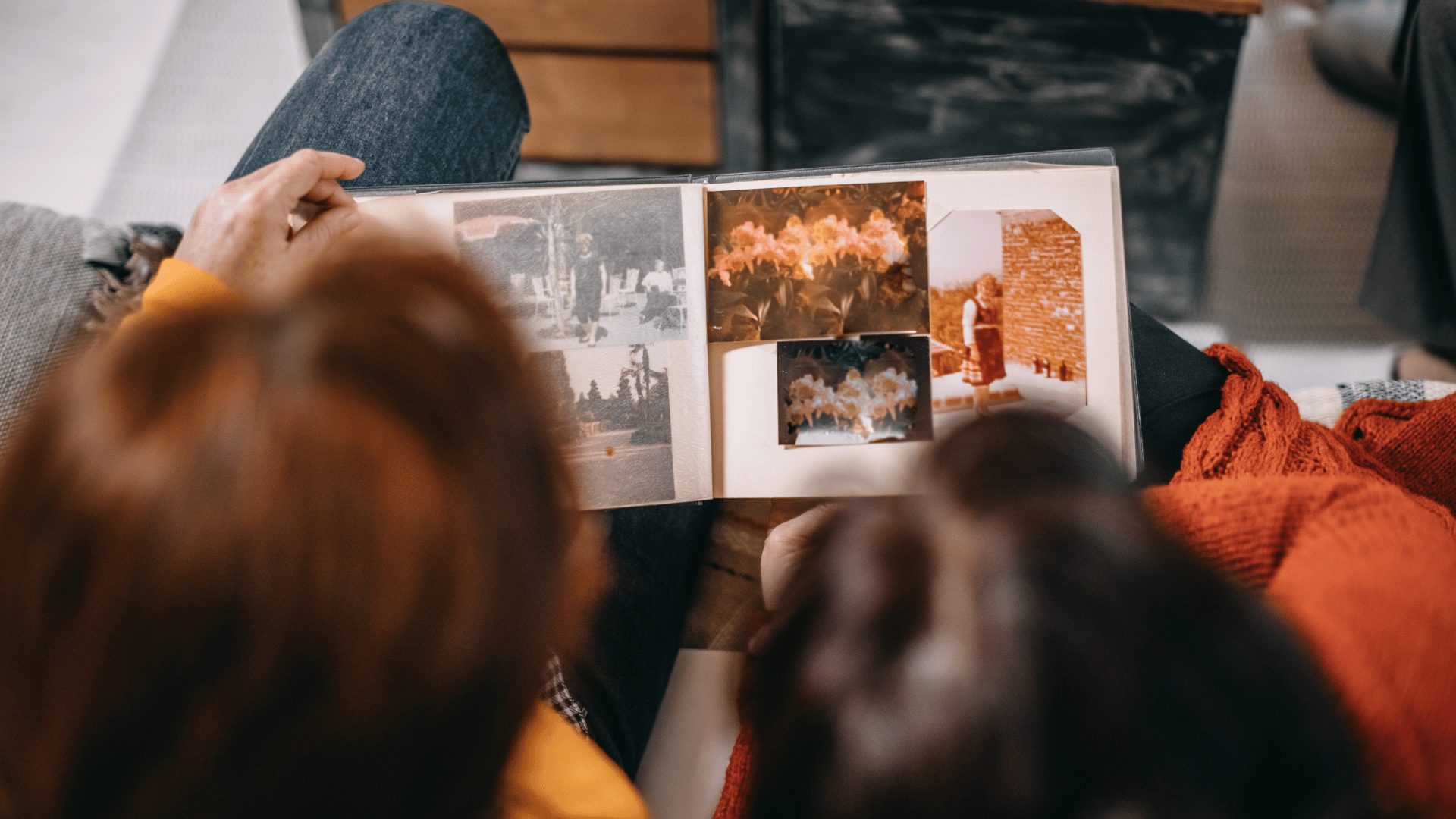 Visão de duas mulheres olhando um álbum de fotografias.