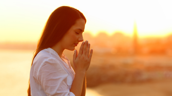 Mulher fazendo o símbolo 'namastê'