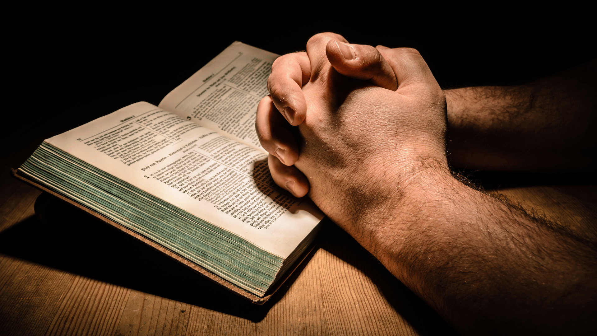 Mãos brancas e masculinas sobre uma bíblia.