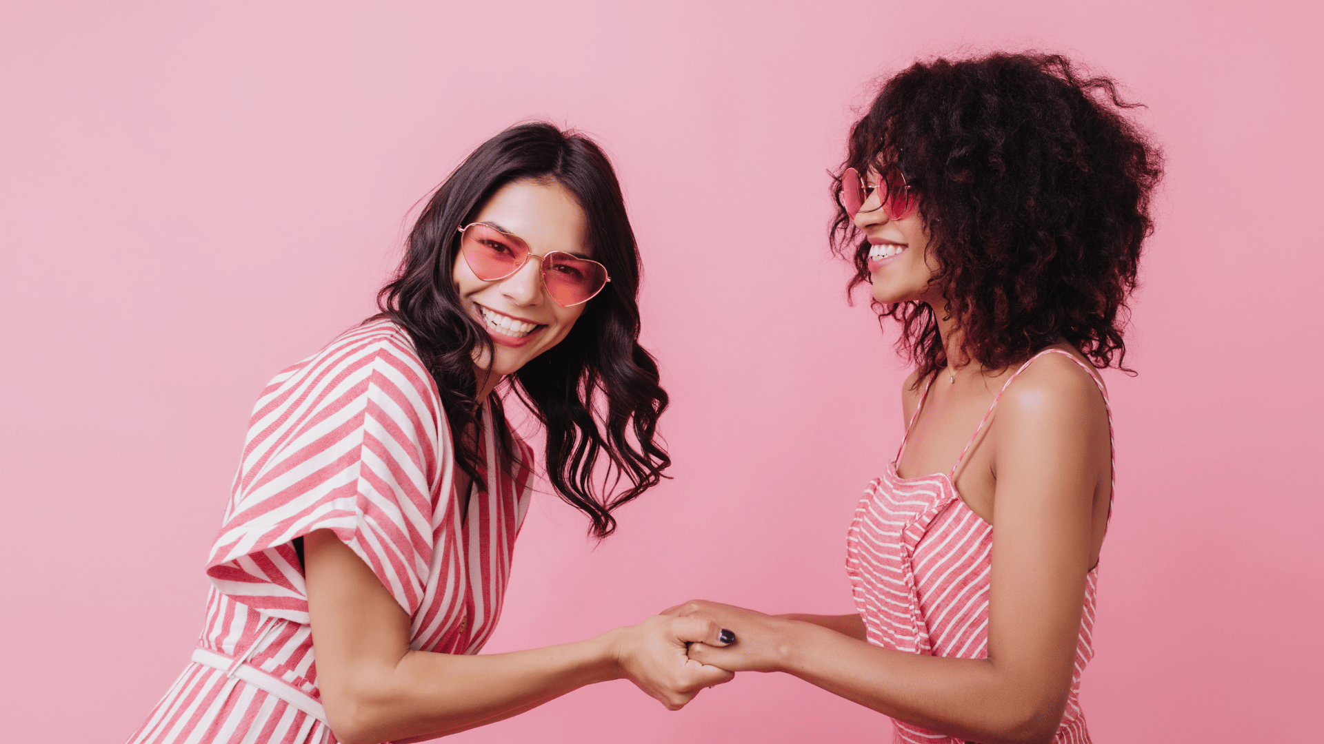 Amigas segurando as mãos uma da outra.