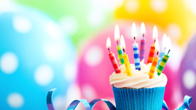 Cupcake com velas e com decoração de aniversário