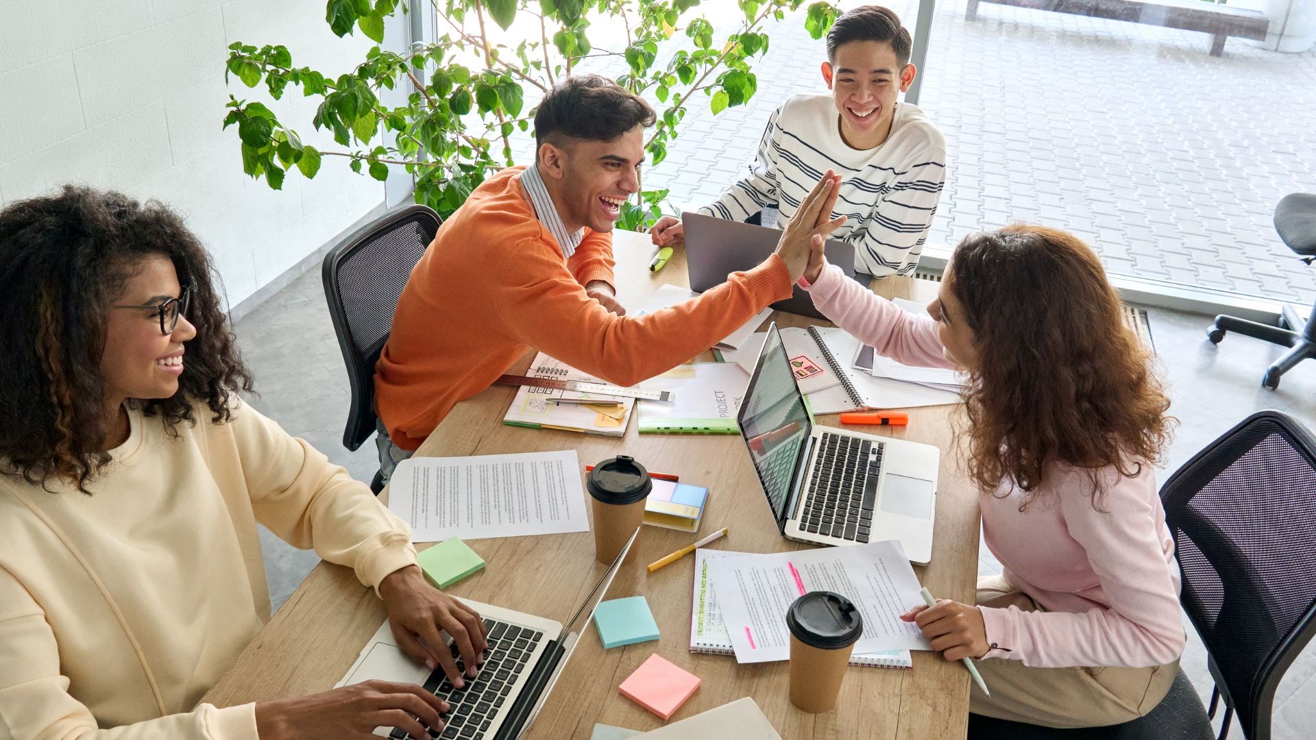 Equipe de trabalho na mesa de escritório, comemorando algo