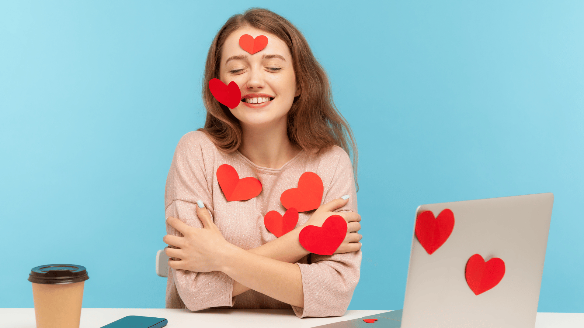 Mulher sentada em frente a computador cheia de corações vermelhos. Conceito de amor próprio.