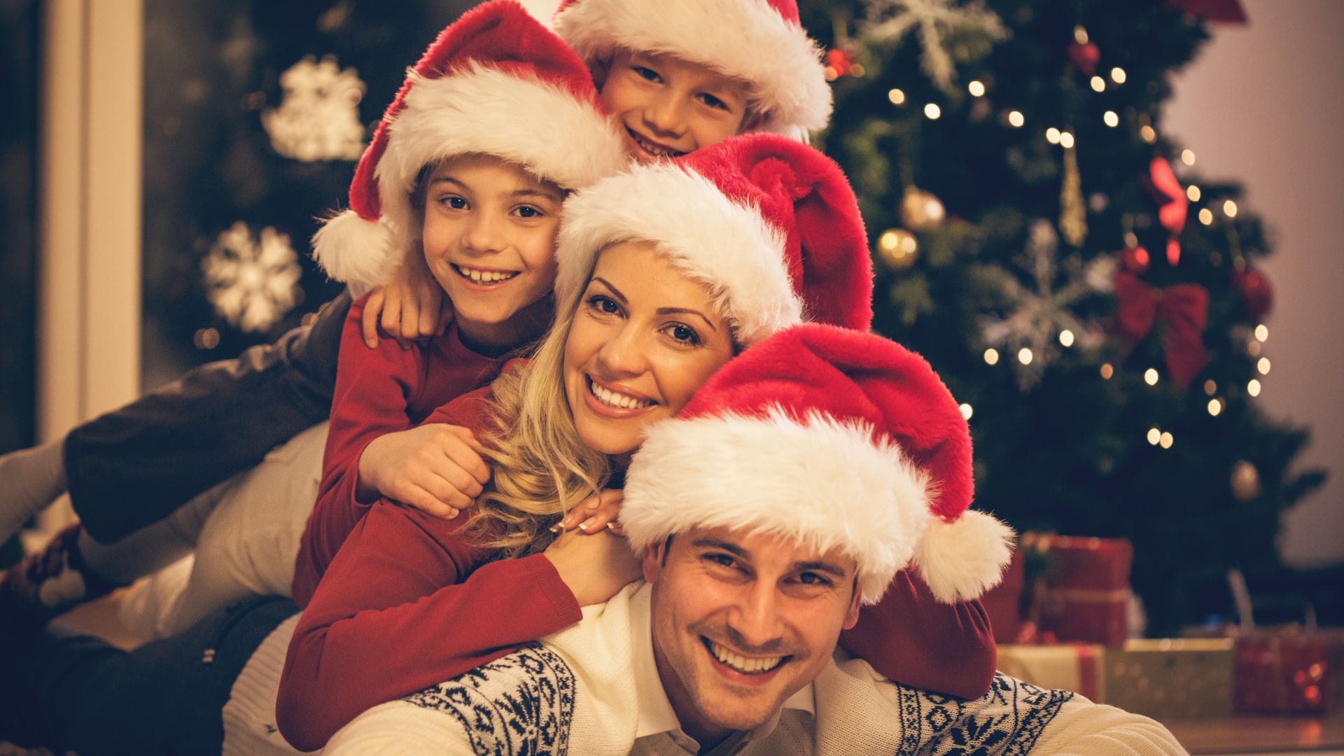 Família feliz comemorando o natal, enquanto posa para foto.